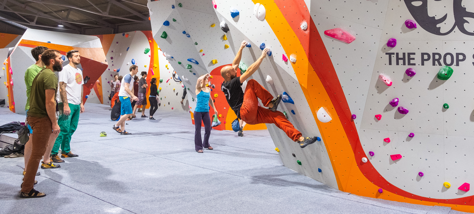 Person bouldering on climbing holds inside climbing gym