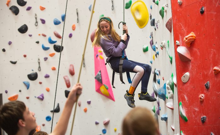 Teenage girl climbing indoors.