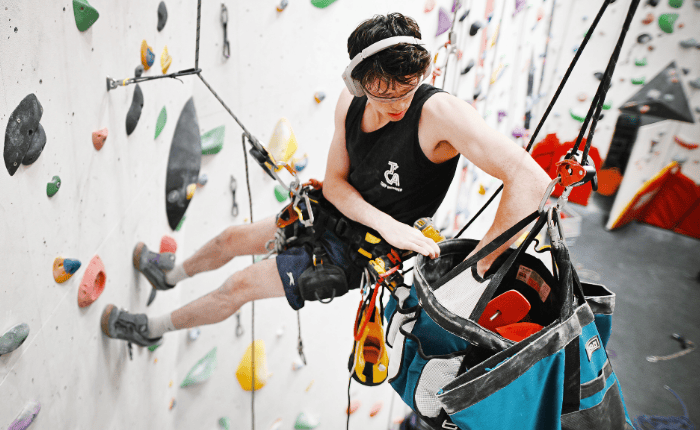 Ben Harvey pictured hanging form ropes along with routesetting gear.