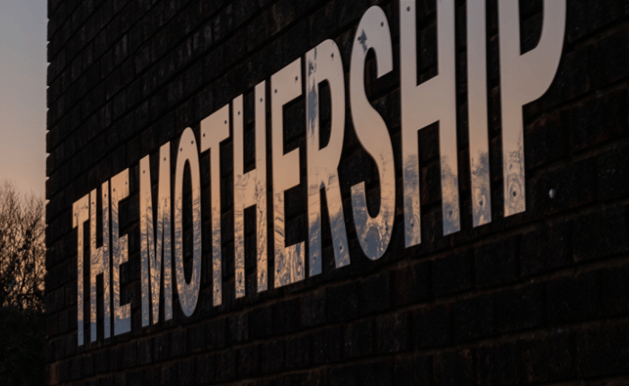 A sunset reflected on The Mothership signage outside the centre