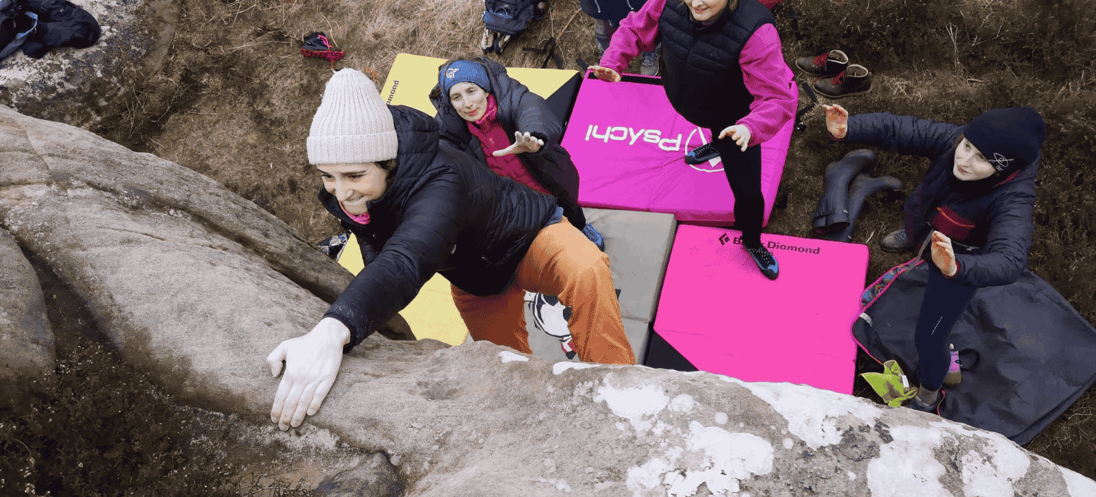 A boulderer slaps to reach the top of a problem outdoors